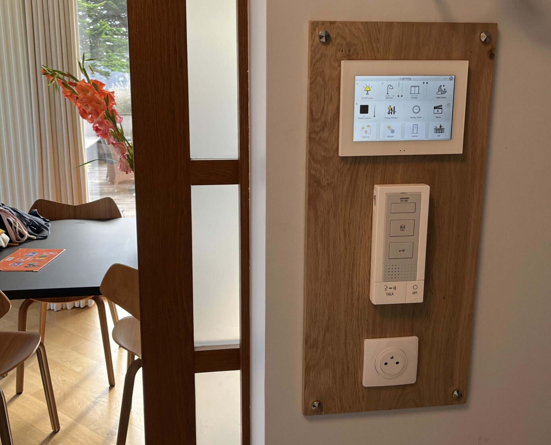 Écran KNX Zennio Z70 et interphone AIPHONE sur un support en chêne assorti aux boiseries de l’entrée